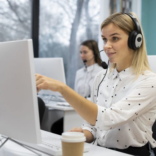 blond-woman-working-in-call-center-with-headphones-and-computer